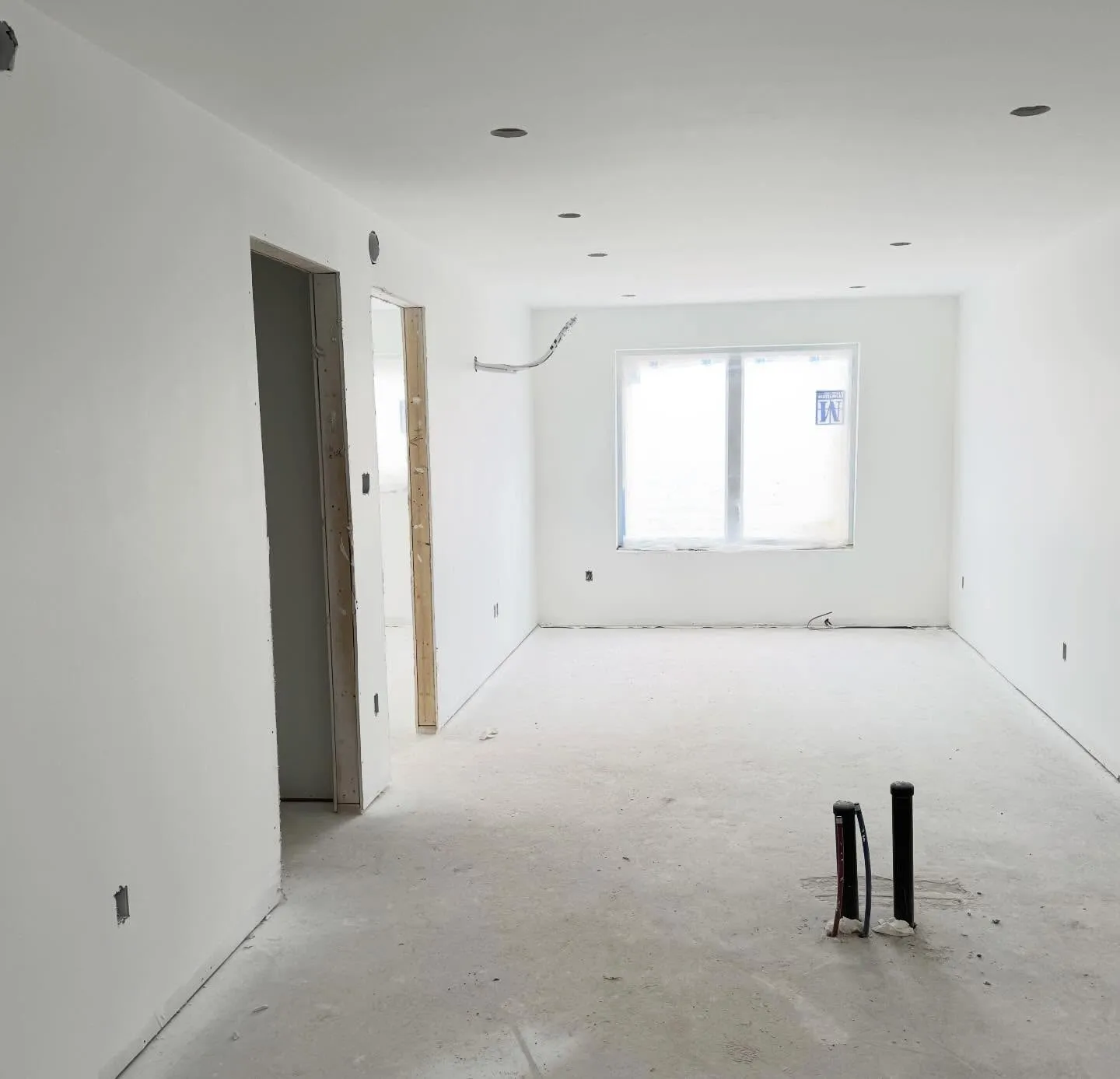 A room primed white, casing set, ready for paint